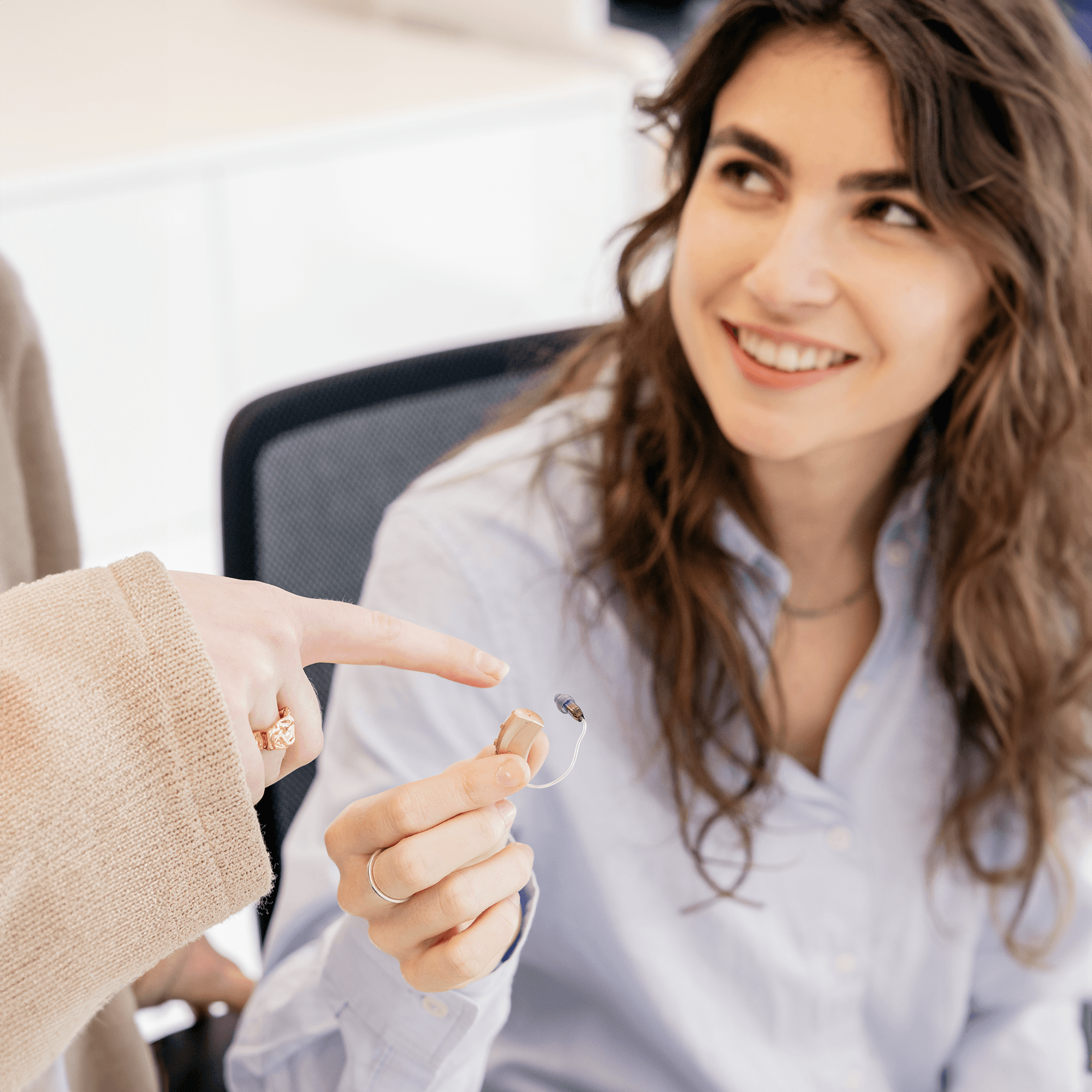 Medewerkster met hoortoestel in de hand